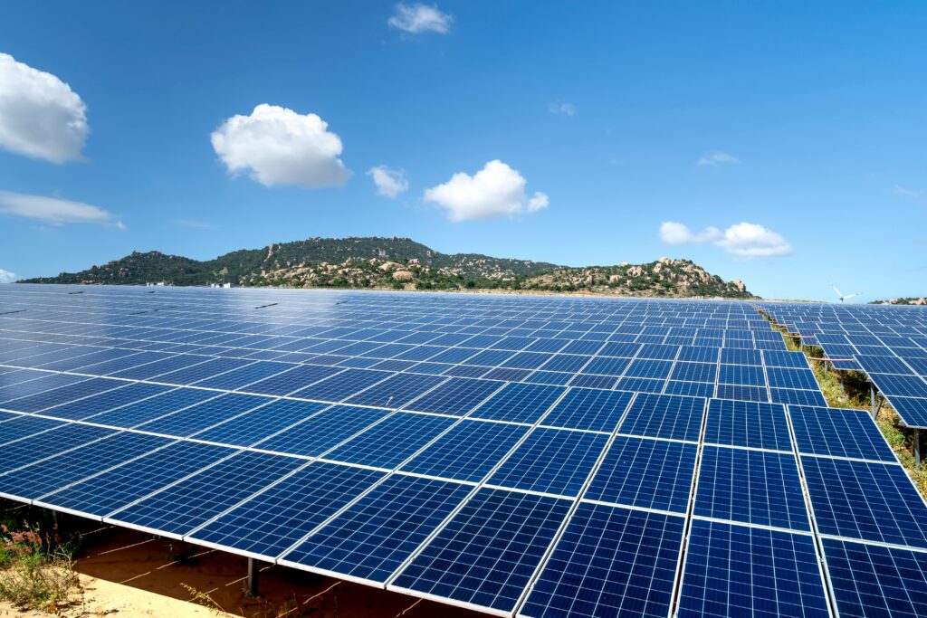 A sprawling solar farm with blue solar panels under a vibrant sky, showcasing renewable energy.